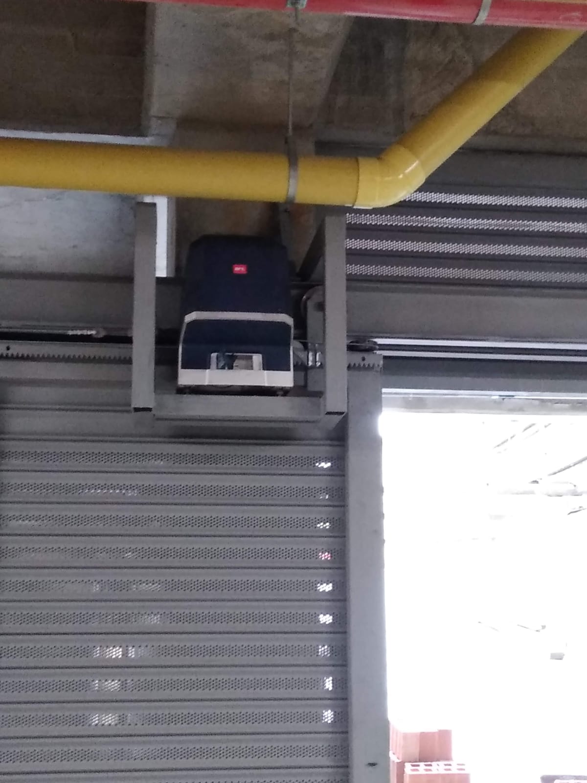 Cortina metálica enrollable con motor instalada en una bodega